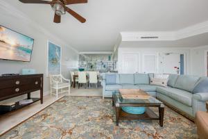 a living room with a blue couch and a table at Phoenix on the Bay 1320 in Orange Beach