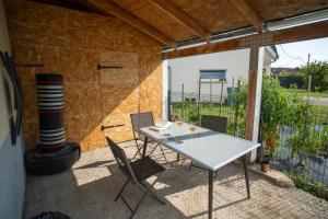a patio with a table and chairs and a heater at Le Bollwiller Piscine Jacuzzi Vignoble in Bollwiller