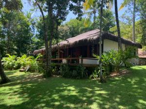 a small house with a thatch roof at Bangalô 12 in Porto Seguro