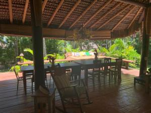 a patio with a table and chairs on a deck at Bangalô 12 in Porto Seguro +8 photos