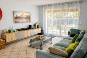 a living room with a couch and a tv at Le Petit Paradis Lescurien in Lescure-dʼAlbigeois