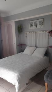 a bedroom with a large bed with white sheets and pillows at O'jardin in Arthez-de-Béarn