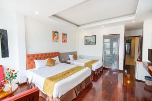 a hotel room with two beds and a television at Catinal Hotel in Danang