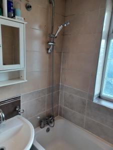 a bathroom with a shower and a sink and a tub at Christian Guest House 1 in Luton