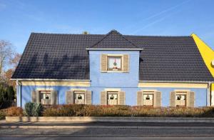 ein blaues Haus mit schwarzem Dach in der Unterkunft MPK Motorsport Apartment in Waldsassen