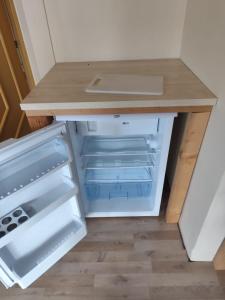 an empty refrigerator with its door open in a kitchen at Boxenstop in Kleinlobming