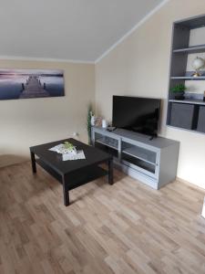 a living room with a coffee table and a flat screen tv at Boxenstop in Kleinlobming
