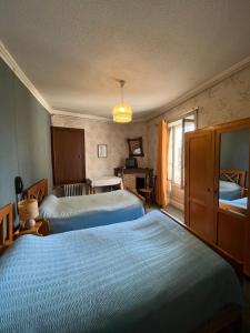 a hotel room with two beds and a desk at Ancien hotel Bourgeois in Andelot-en-Montagne