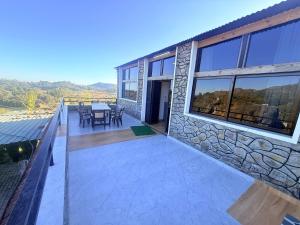 a balcony of a house with a table and chairs at Dev Cottage in Mount Ābu