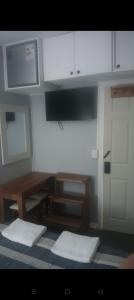 a kitchen with white cabinets and a table and a door at Hostal Don Francisco in Osorno +9 photos