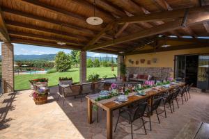 a patio with a long wooden table and chairs at Villa Farmi by MMega in Bibbiena