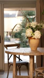 a vase of flowers sitting on a wooden table at The Library in Moreton in Marsh