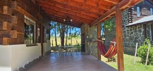 a porch of a stone house with a hammock at Ribera Calma in Los Reartes