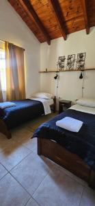 a bedroom with two beds and a wooden ceiling at Ribera Calma in Los Reartes