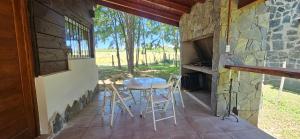 a patio with a table and chairs on a porch at Ribera Calma in Los Reartes