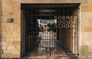 an iron gate with a doorway to a house school at Schoolhouse Snug in Moreton in Marsh