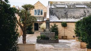 a house with a statue in front of it at Schoolhouse Snug in Moreton in Marsh