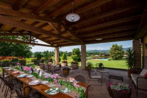 a patio with a long table with flowers on it at Villa Farmi by MMega in Bibbiena +31 photos