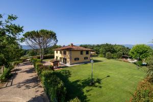 a house with a large yard with a green lawn at Villa Farmi by MMega in Bibbiena