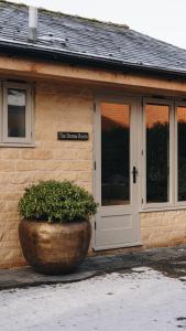 a building with a large pot in front of a door at The Drama Studio in Moreton in Marsh