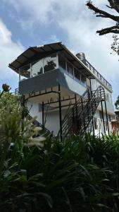 a small house with a balcony on top of it at Cloud Crest Homestay in Ooty