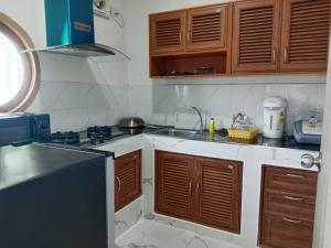 a kitchen with wooden cabinets and a sink at เดอะโดมโฮมสเตย์ ม่อนแจ่ม in Mon Jam