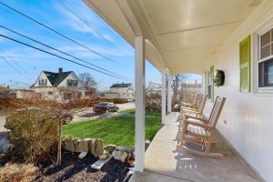 a porch of a white house with two rocking chairs at Ledge on Green in Rockport