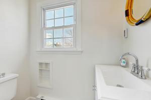 a white bathroom with a sink and a window at Ledge on Green in Rockport +22 photos