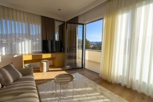 a living room with a couch and a large window at Hotel Allegra in Prishtinë