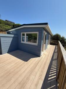 a small blue house with a wooden deck at Recently renovated beach shack with a view in Antony