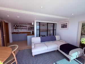 a living room with a white couch and a kitchen at Recently renovated beach shack with a view in Antony