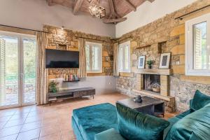 a living room with a couch and a tv at Villa Palataki III in Kardamyli