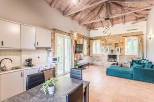a kitchen and living room with a blue couch at Villa Palataki III in Kardamyli