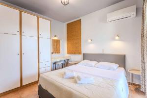 a bedroom with a large bed and a desk at Villa Palataki III in Kardamyli +17 photos
