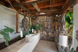 a bathroom with a sink and a stone wall at El Sueño de Mamá in Tegueste