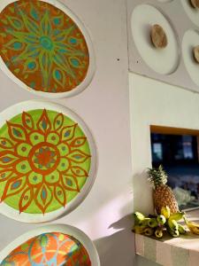 three plates on a wall with a pineapple on a shelf at Rock Hill Hotel in Galle
