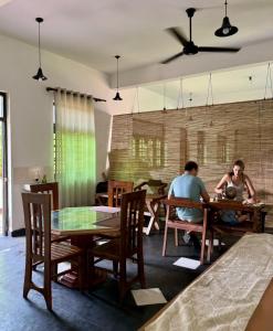 two people sitting at tables in a restaurant at Rock Hill Hotel in Galle