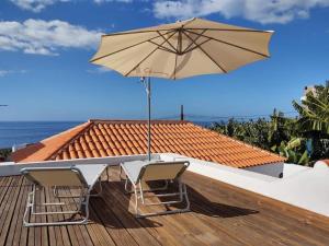 a table with two chairs and an umbrella on a deck at Casa Los Morros in Tazacorte