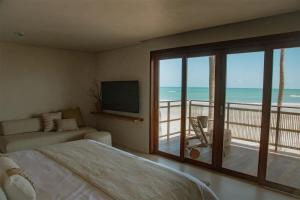 a bedroom with a bed and a view of the ocean at Lahaina Hotel in Icaraí