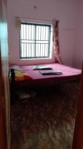 a bed in a room with a window at Vitthala rukmini in Gokarna +12 photos