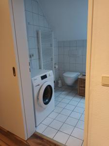 a bathroom with a washing machine and a toilet at Apartment am Vechtesee in Schüttorf +70 photos