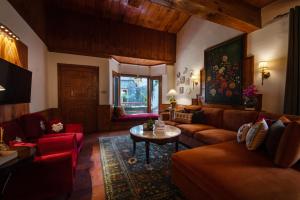 a living room with couches and a table in a room at Secret Garden Kalam in Kalām