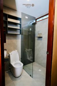a bathroom with a toilet and a glass shower at Privada Villa Siargao in General Luna +10 photos