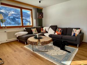 a living room with a couch and a black dog at Whiteberg Apartment in Schruns