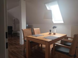 a dining room table with chairs and a window at Apartment am Vechtesee in Schüttorf