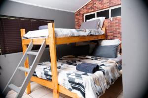 a bedroom with two bunk beds and a brick wall at Falcon Lodge (S) in Bela-Bela +18 photos