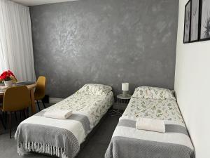 a bedroom with two beds and a table with a tableablish at Apartament Szpitalna Możliwość wystawiania Faktur, WI-FI in Suwałki