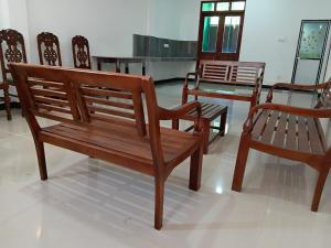 a group of wooden benches sitting in a room at Velora Resort in Anuradhapura