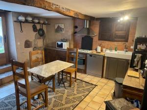 a kitchen with a table and chairs in a kitchen at Maison de caractère in Les Bordes-sur-Arize