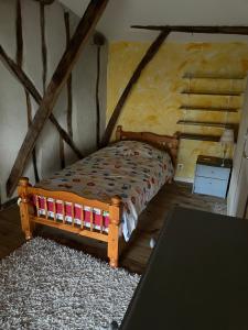 a small bedroom with a bed and a table at Maison de caractère in Les Bordes-sur-Arize